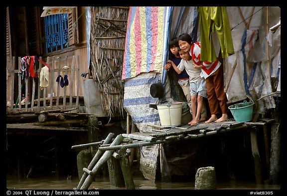 Children peering from their waterfront house. Can Tho, Vietnam (color)